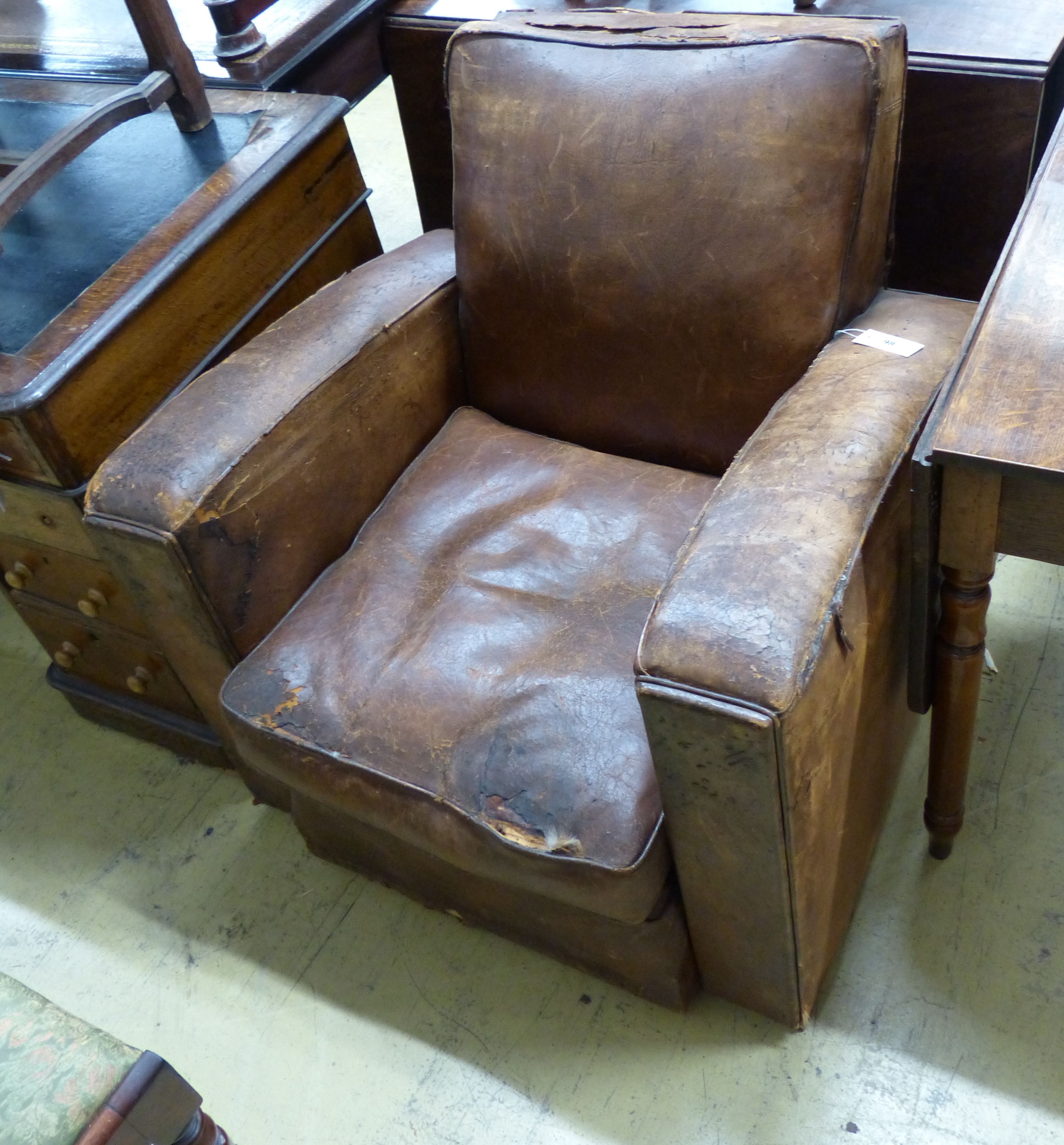 A 1930's French distressed leather club armchair, width 81cm